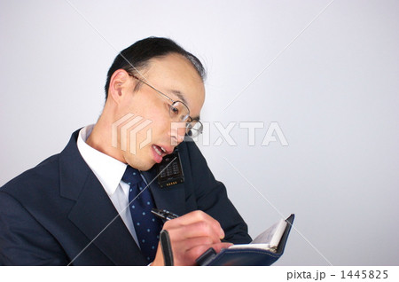 電話しながら記入する中年ビジネスマン 1445825