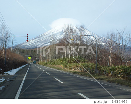 春の笠雲を被る羊蹄山と国道 1452445