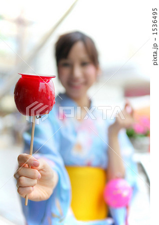 りんご飴を持つ女性の写真素材