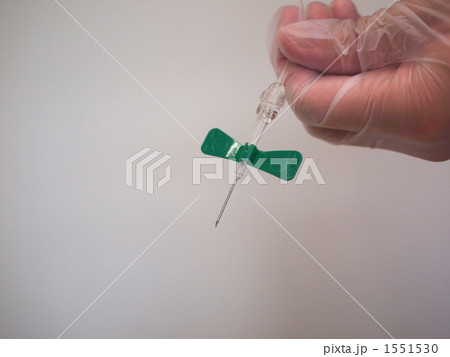 プラスチック手袋をはめ翼状針を持つ手 1551530