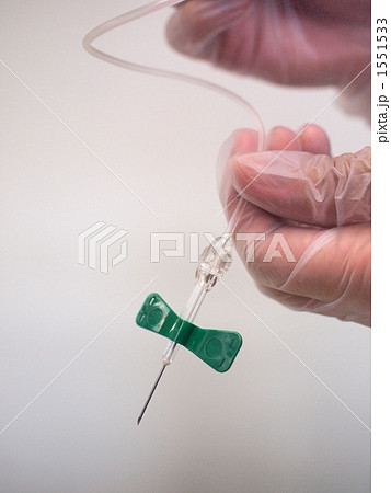 プラスチック手袋をはめ翼状針を持つ手 プラスチック手袋をはめ翼状針を持つ手 1551533