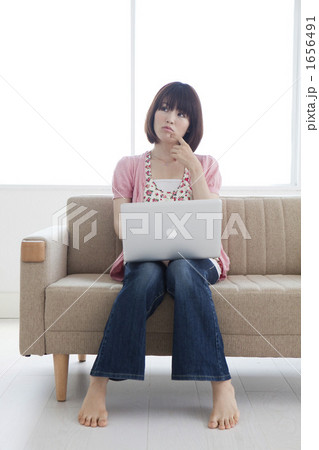 ソファでパソコンを操作する若い女性 1656491