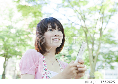 携帯電話を操作する女性 携帯電話を操作する女性 1660625