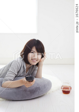 リモコンを持つ若い女性 1676624