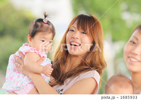 赤ちゃんを抱き上げる若いママの写真素材