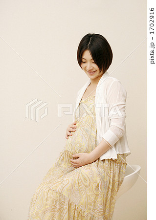 お腹をさする妊婦さんの写真素材