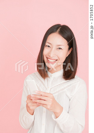 メールをする笑顔の女性 メールをする笑顔の女性 1705852