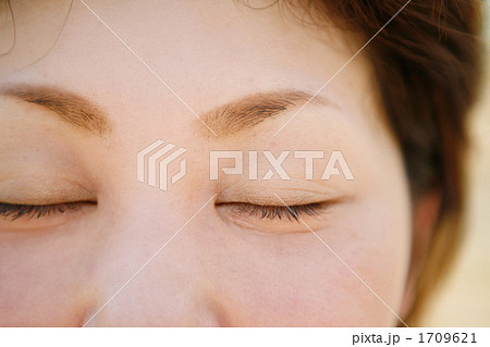 目を閉じた女性の顔アップの写真素材
