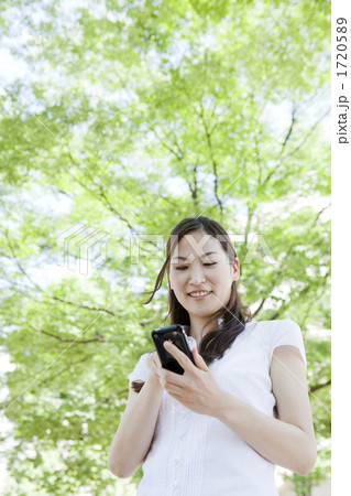 屋外でスマホを操作する若い女性 1720589
