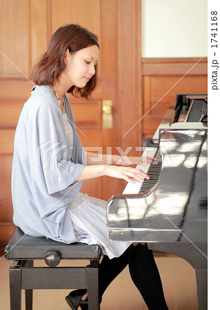 ピアノを弾く若い女性の写真素材