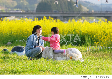 菜の花が咲く河川公園で遊ぶ親子 1749535