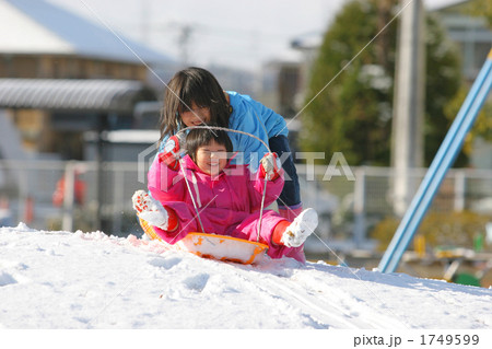 雪の公園でそり遊びする姉妹2人 雪の公園でそり遊びする姉妹2人 1749599