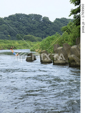 川に飛び込む男の子の写真素材