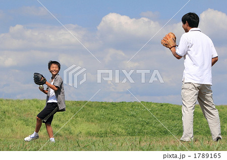 休日キャッチボールをする親子の写真素材