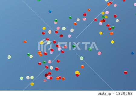 青空に飛ぶたくさんの風船の写真素材