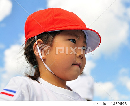 運動会で見つめる女の子 赤白帽子 横顔 の写真素材