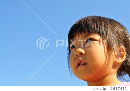 真剣な表情で見つめる女の子（青空） 1937432