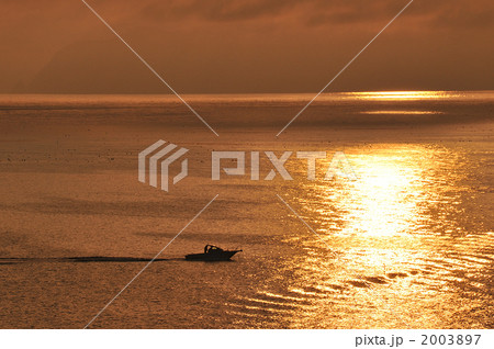 夕焼けの海を走る一隻の船 2003897