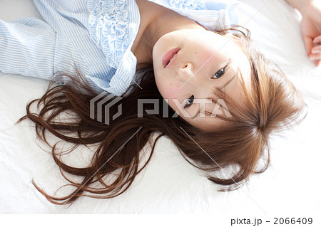 ベッドに寝転がる女の子の写真素材