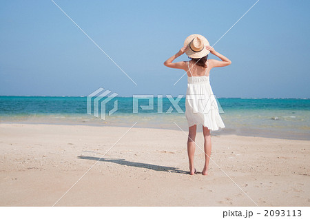 海辺に立つ女性の後ろ姿の写真素材