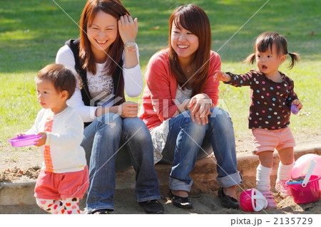 子どもを遊ばせて公園の砂場で話し込むママ友たち 2135729