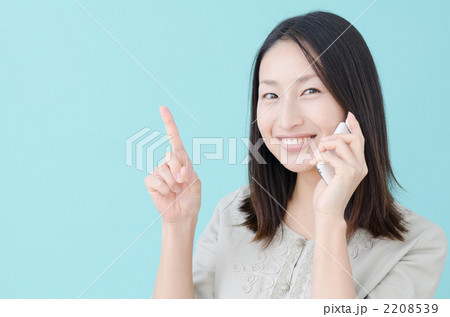 ケータイで話す20代の女性（ブルーバック） 2208539