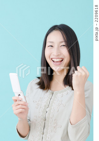 メールをする20代の女性(ブルーバック) メールをする20代の女性(ブルーバック) 2209618