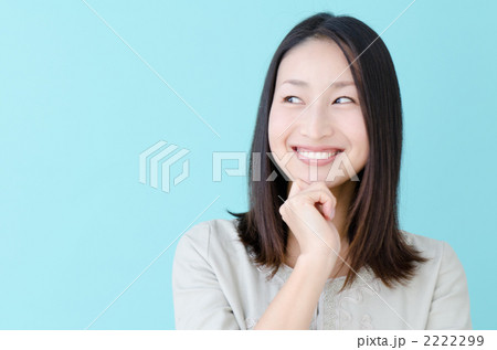 頬杖をつく20代の女性（ブルーバック） 2222299