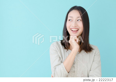 頬杖をつく20代の女性(ブルーバック) 頬杖をつく20代の女性(ブルーバック) 2222317