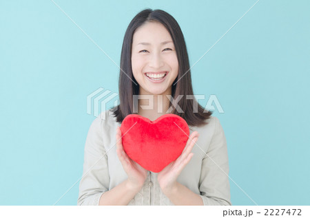 ハートを持つ20代の女性（ブルーバック）の写真素材 [2227472] - PIXTA 