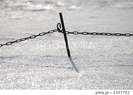 雪に埋まる鉄杭とチェーン 2307702