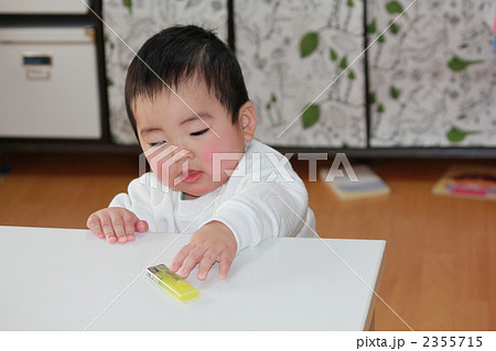 テーブルのたばこを取ろうとする赤ちゃん 2355715