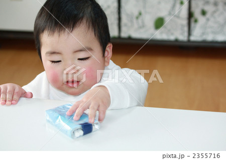 テーブルのたばこを取ろうとする赤ちゃん テーブルのたばこを取ろうとする赤ちゃん 2355716