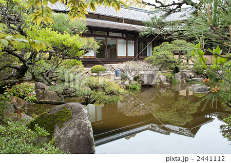 日本庭園の池に写る日本家屋の写真素材