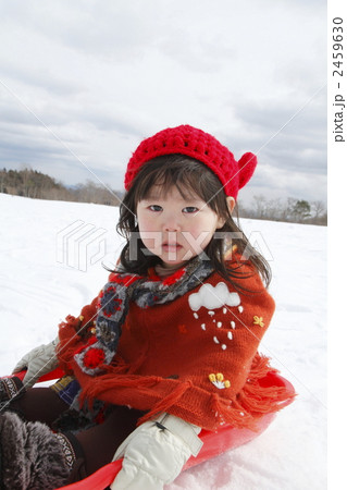 雪で遊ぶ2歳の女の子の写真素材