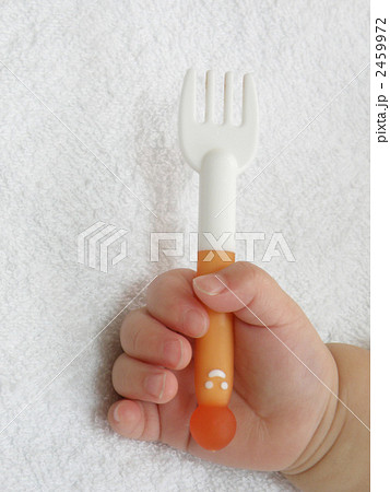 フォークを握る赤ちゃんの手の写真素材