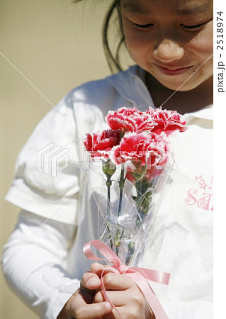 カーネーションの花束を大事そうに持つ女の子 2518974