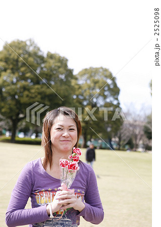 カーネーションの花束を嬉しそうに持つ女性 2525098