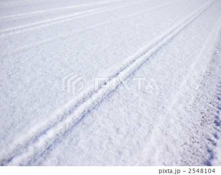 自転車の轍が残る雪道の写真素材