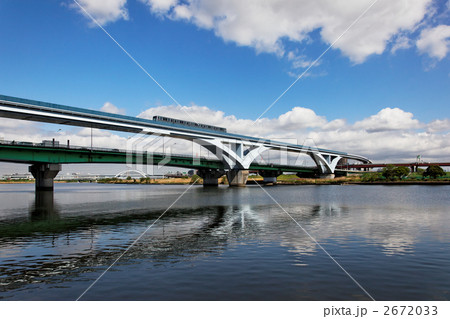 青空の下、荒川に架かる扇大橋と通過中の舎人ライナー 2672033
