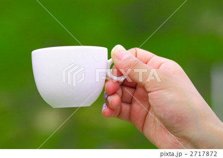 コーヒーカップを持つ手の写真素材