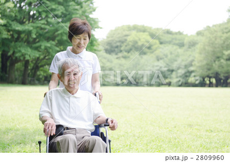 車椅子に乗った夫と散歩する妻 2809960