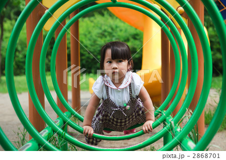 公園の遊具で遊ぶ3歳の女の子の写真素材