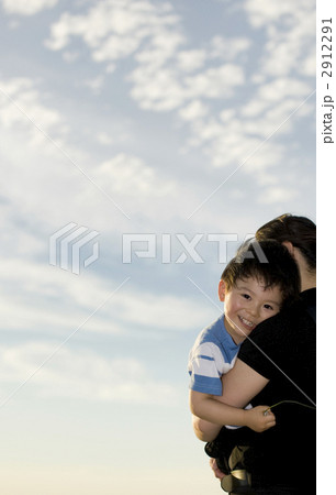 青空の下だっこをされる三歳男児 2912291