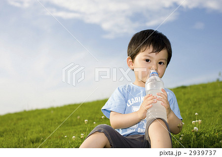 青空のもとで水を飲む三歳の男児 2939737