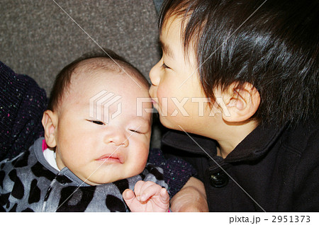 赤ちゃんにキスする男の子の写真素材