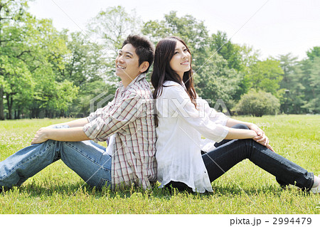 背中合わせ カップル 友達の写真素材