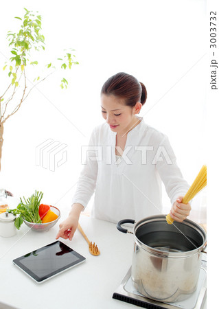 iPadを見ながら料理する女の子 3003732