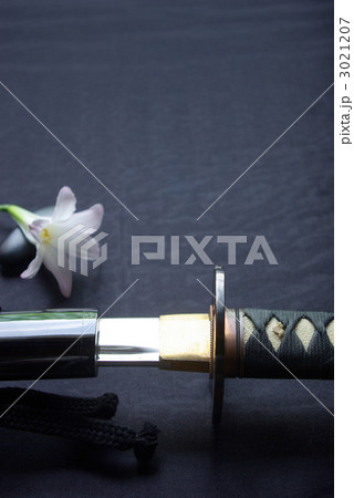 抜きかけの居合練習刀と清楚な花一輪（縦） 3021207