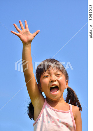 青空で手を上げる女の子 夏 の写真素材